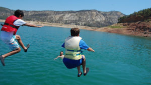 Dos chicos en e aire tras un gran salto al agua